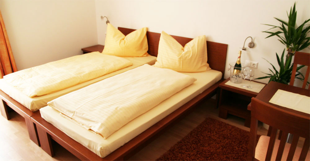 Hotelbett mit gelber Bettwäsche in einem Hotel mit WLAN im Bezirk Weiz